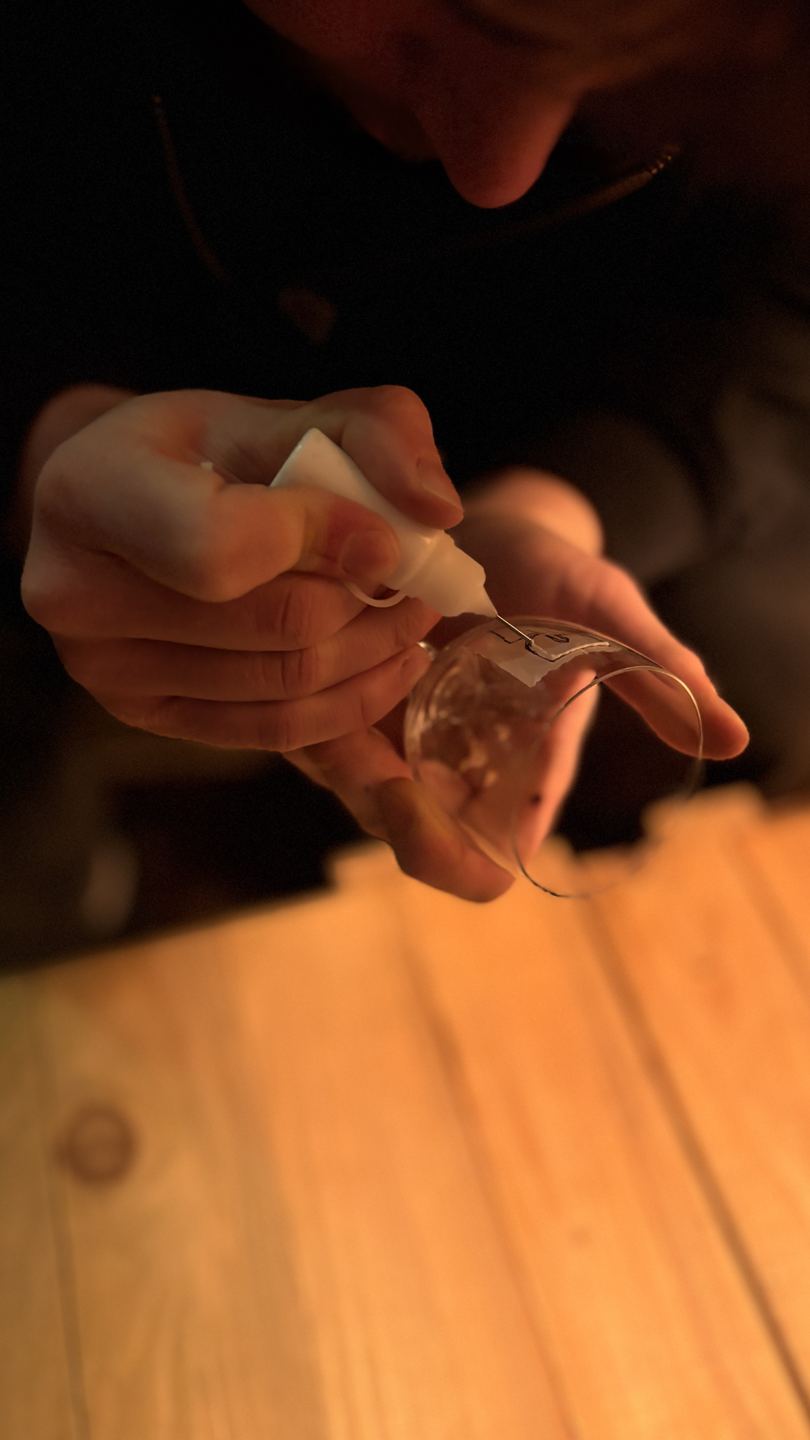 Hände bemalen ein Glas im Workshop